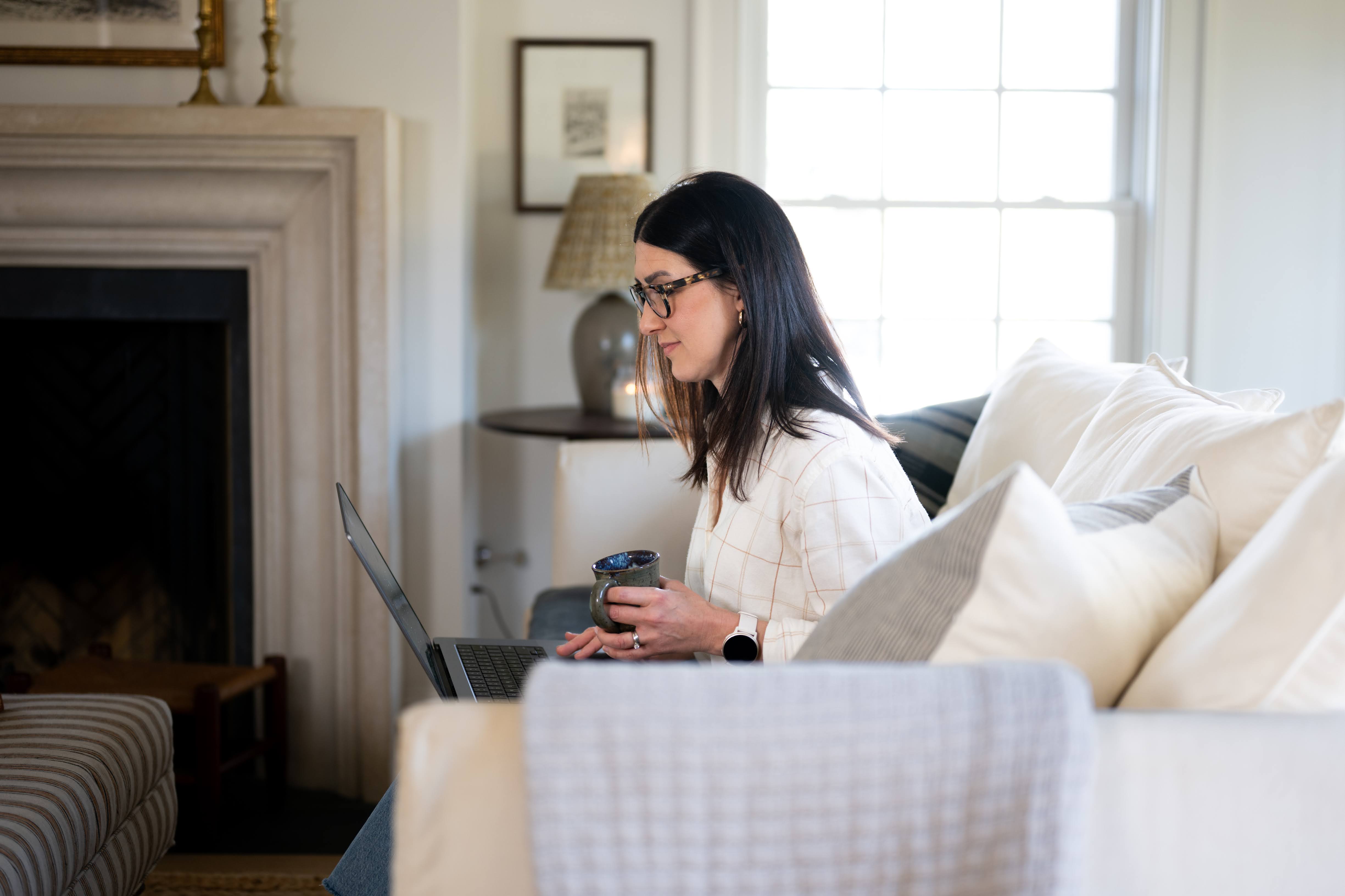 Woman on couch using a laptop