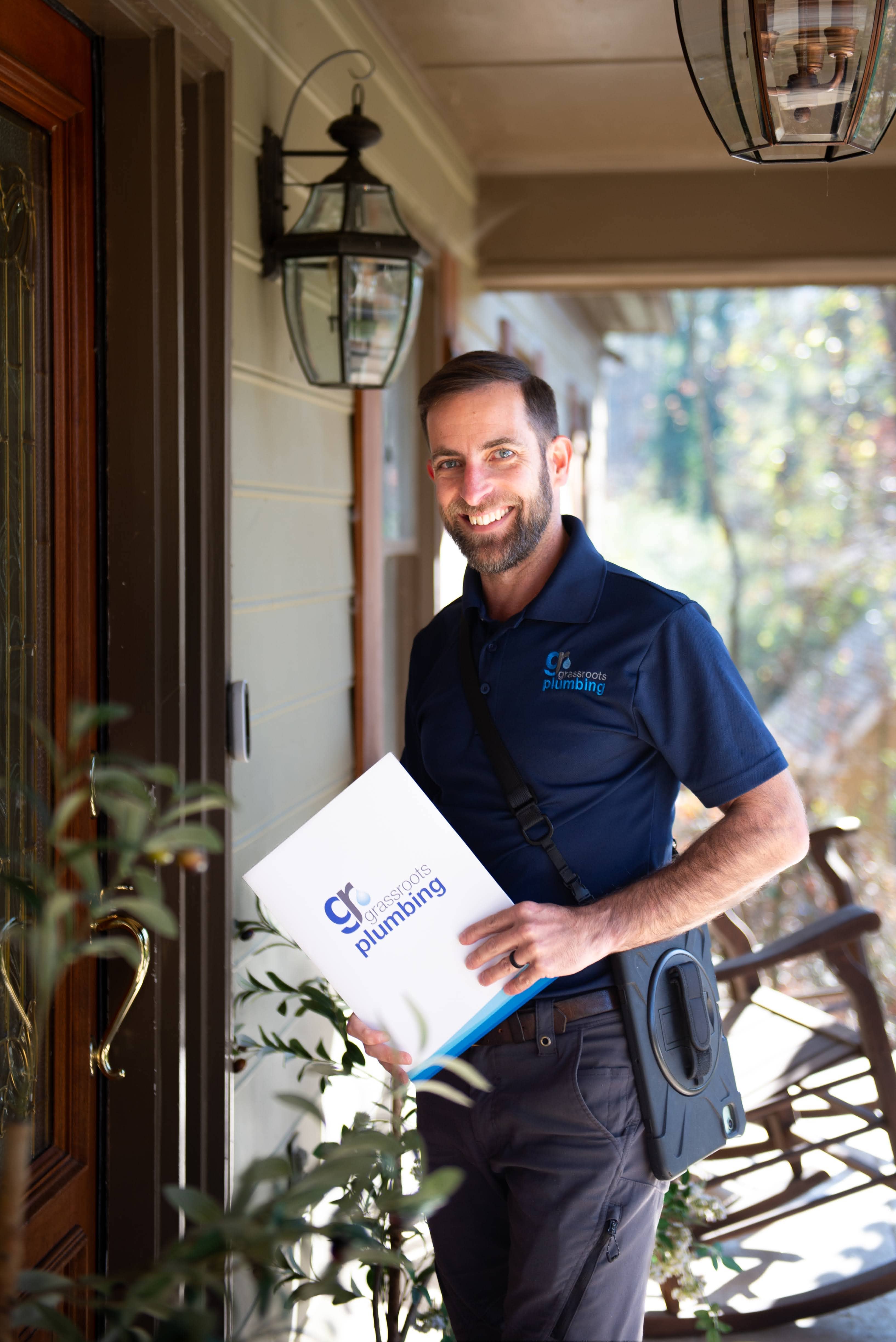 man in grass roots logo shirt approaching door